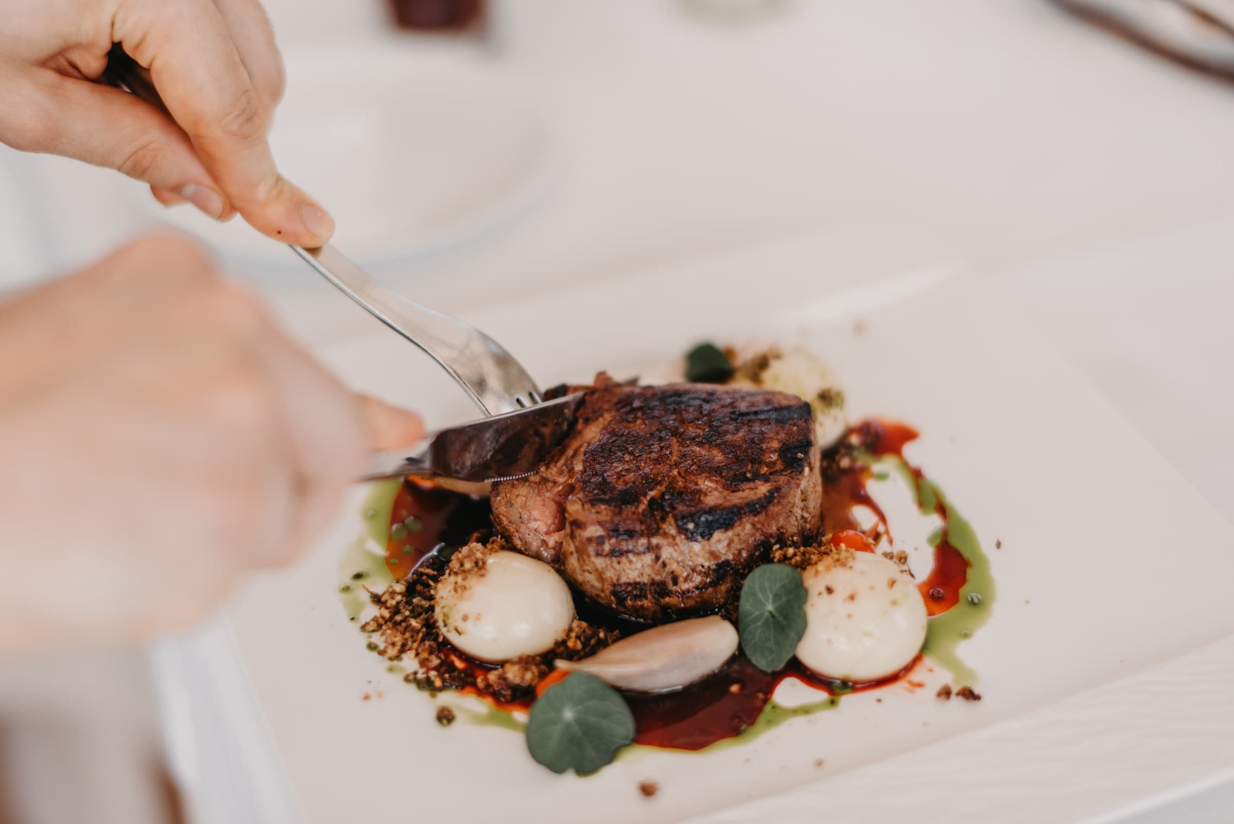 Rib-eye from the wood-charcoal gradele being cut at the table, Zori Restaurant, Palmižana
